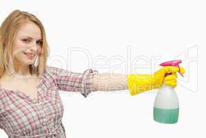 Smiling young woman holding a spray bottle