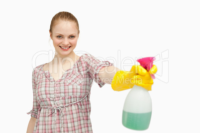Joyful woman holding a spray bottle while smiling