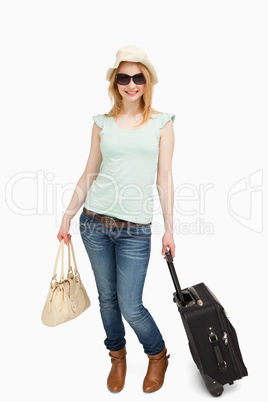 Woman smiling while holding luggages