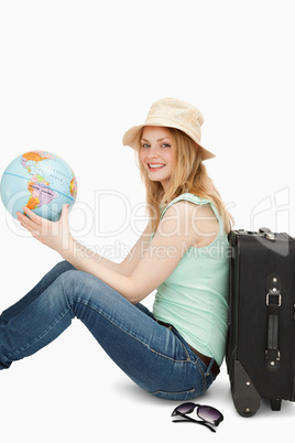 Young woman smiling while holding a world globe