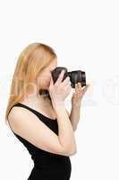 Blonde-haired woman aiming with a camera