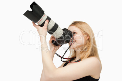 Woman aiming with a SLR camera while smiling