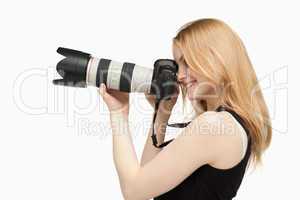 Woman smiling while holding a SLR camera