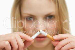 Close up of a young woman breaking a cigarette