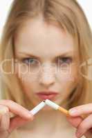 Close up of a serious woman breaking a cigarette