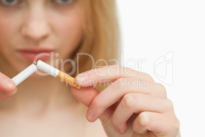 Close up of the hands of a woman breaking a cigarette