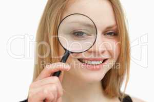 Woman placing a magnifying glass on her eye