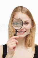 Joyful woman using a magnifying glass