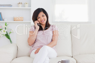 Woman with a smile on her face sitting on a couch