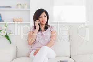 Woman sitting on a couch holding a phone