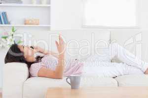 Woman relaxing on a sofa while phoning
