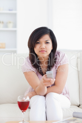 Woman sitting on a couch holding a remote
