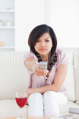 Woman looking at television while she sits on a couch