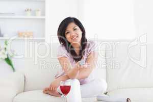 Woman sitting on a couch and holding a television remote