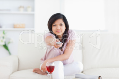 Woman pressing on a television remote