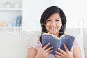 Woman smiling while holding a book