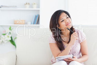 Smiling woman holding a pen and a notebook