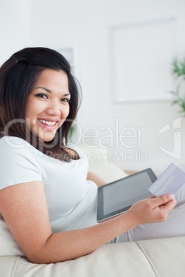 Woman smiling while holding a card and a tactile tablet