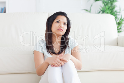 Woman is sitting in front of a couch