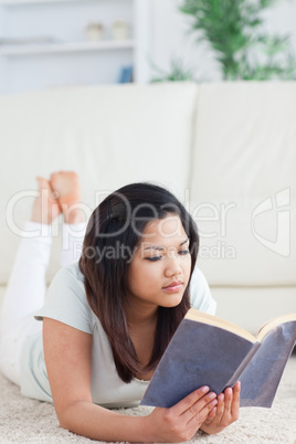 Woman lying on the floor reading a book Woman lying on the floor reading a book