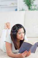 Woman lying on the floor reading a book