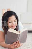 Woman lying on the floor and reading a book