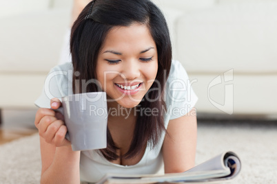 Smiling woman holding a cup and a magazine