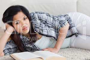 Woman on the floor holding her head with her hand