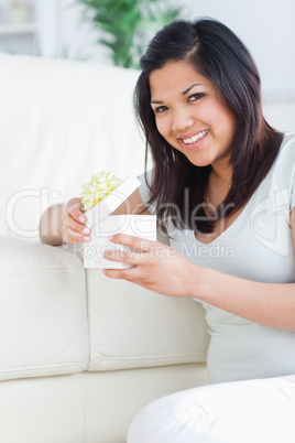 Woman smiling while opening a gift box