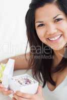 Close-up of a smiling woman holding an open gift box