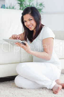 Smiling woman holding a tactile tablet in front of a couch