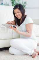 Smiling woman holding a tactile tablet in front of a couch