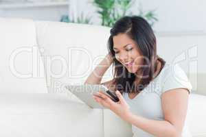 Woman playing with a tactile tablet while sitting on the floor