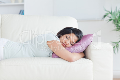 Woman holding a pillow while sleeping on a couch