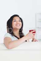 Woman smiles as she holds a glass of red wine