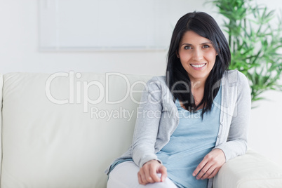 Smiling woman sitting at the end of a couch