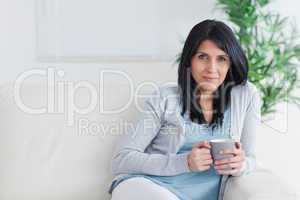 Woman relaxing on a couch while holding a mug