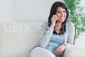 Woman talking on the phone while relaxing on a couch