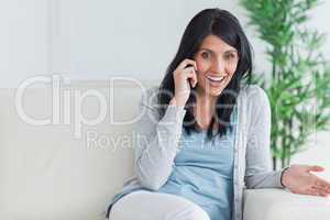 Woman talking on the phone while resting on a couch