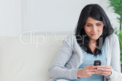 Woman holding a telephone while relaxing on a couch