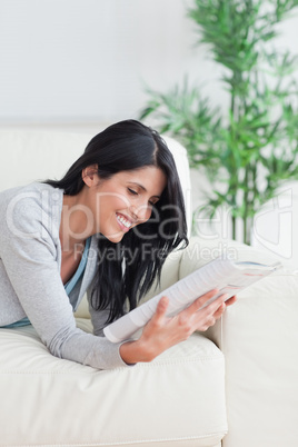 Woman smiling while she reads a magazine