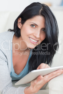 Close up of a smiling woman playing with a tablet