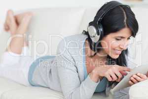 Woman with headphones on while playing with a tablet