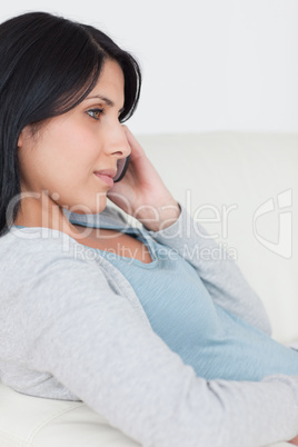 Woman with a phone in her hand while sitting on a couch