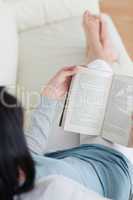 Woman reading a book with her legs crossed