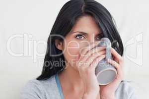 Woman drinking from a mug that she holds with two hands