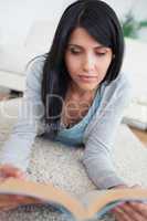 Woman reading a book while lying on the floor