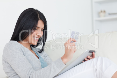 Woman holding up a card and a tablet