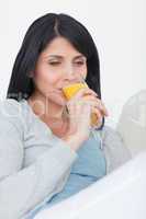 Woman drinking from a glass of orange juice