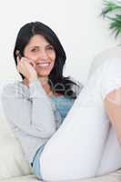 Woman telephoning while sitting on a couch